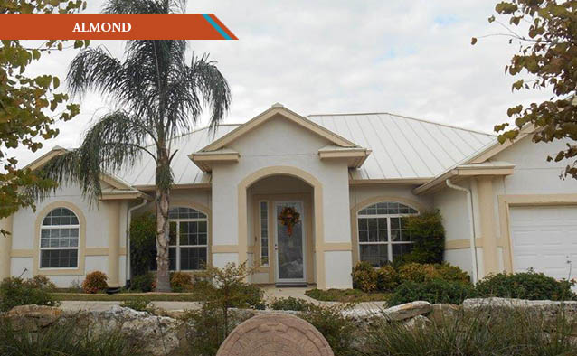 An Almond style metal roof on a white stucco with yellow trim one story house.