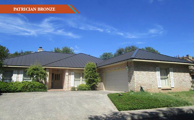 A Patricia Bronze style metal roof on a white brick one story house with driveway in front of the house.
