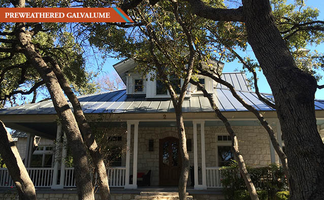 A Preweathered Galvalume style roof on a white two story rock house with wrap around front porch.