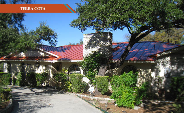 A Terra Cota colored metal roof on a white brick one story Ranch style house.